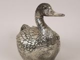 a silver duck sitting on top of a metal container