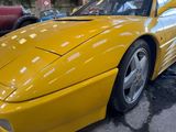yellow sports car parked on the side of the road in a parking lot