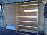 a wooden shelf in the back of a van