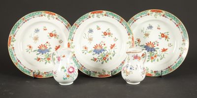 four pieces of china on a table with a vase and plate