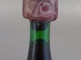 a wine bottle that has a pink stone on top of it