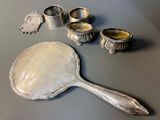 a mirror, spoon, and cups on a table
