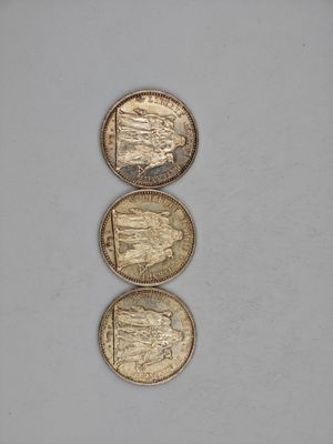 three gold coins sitting on top of each other on a white surface