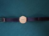 a close up of a wrist watch on a green surface