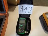 a green and black meter sitting on a table next to other items