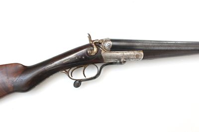 un vieux pistolet avec une poignée en bois sur une surface blanche