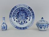 une assiette bleue et blanche et deux vases posés sur une table