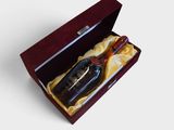 une bouteille d'alcool dans un coffret, posée sur une surface blanche
