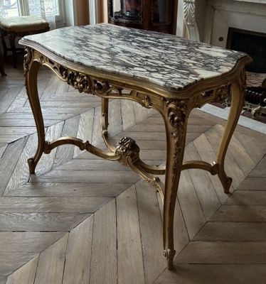 a marble topped table in the middle of a living room