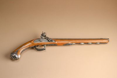 an old gun that is on the wall of a room