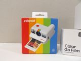 a polaroid camera sitting next to a box of colored film