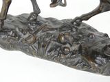 bronze statue of a man on a horse on a rock