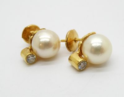 une paire de boucles d'oreilles en perles et diamants sur fond blanc