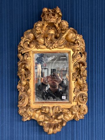 Italie. Miroir en bois doré richement sculpté de putti en rond de...