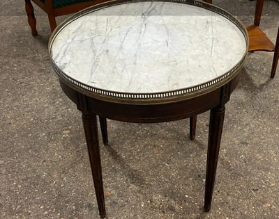 une table avec un plateau en marbre et deux chaises à l'arrière-plan