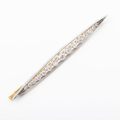 a close up of a silver and gold pen on a white surface