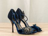 a close up of a pair of blue high heel shoes on a wooden table