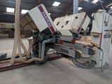 a machine that is cutting wood in a warehouse