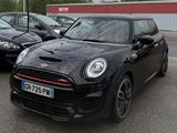 une Mini Cooper noire garée sur un parking à côté d'autres voitures
