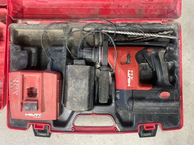 une mallette rouge posée par terre, contenant des outils