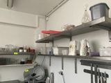 une petite cuisine avec de nombreux objets sur les étagères