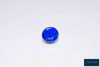 a blue sapphire stone on a white surface