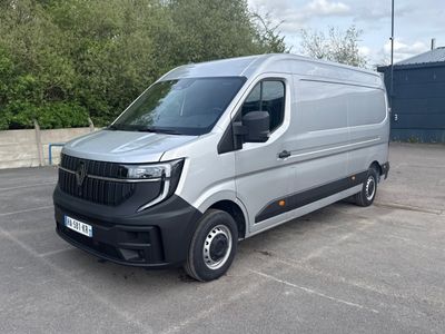 une camionnette argentée garée sur un parking, avec des arbres en arrière-plan