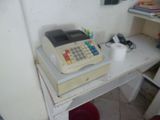 une caisse enregistreuse posée sur un bureau blanc