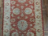 an orange and beige rug on a wooden floor