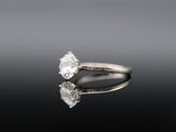 a close up of a diamond ring on a reflective surface