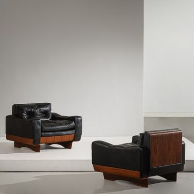 deux fauteuils en cuir noir et une table en bois dans une pièce blanche