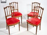 une paire de chaises de salle à manger en velours rouge avec des dossiers sculptés