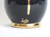 a black vase with a gold cross on it