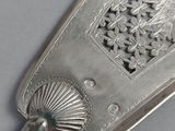 a silver spoon with a handle on a table