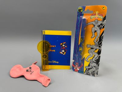 un petit objet rose à côté d'un cahier et d'un objet rose