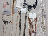a lot of necklaces and bracelets that are on the table