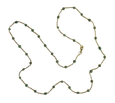 un long collier de perles vertes avec une chaîne dorée sur fond blanc