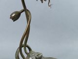 a metal sculpture of a flower that is on top of a plate