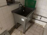 a sink in the corner of a bathroom with a green lid