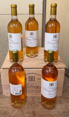 quatre bouteilles de vin sont posées dans une caisse en bois sur une table