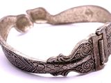 an image of a silver bracelet on a white surface