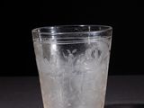 a glass with ice in it sitting on a table