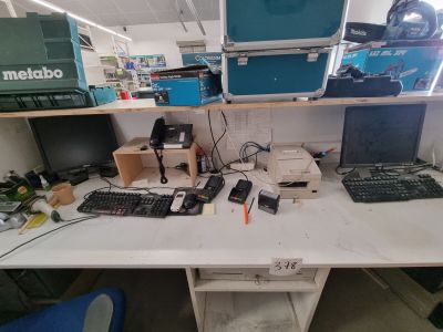 un bureau sur lequel se trouvent un ordinateur, un clavier, une souris et d'autres appareils électroniques