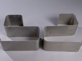 three pieces of metal are sitting on a white surface