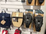 de nombreux sacs et sacs à dos accrochés à un mur dans un magasin