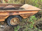 a rusted out trailer sitting in the middle of the woods