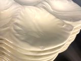 a stack of white plates sitting on top of a table