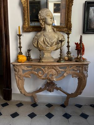 a bust of a woman sitting on a table next to a mirror