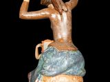 statue of a woman sitting on top of a rock holding a pitcher