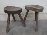 two wooden stools sitting next to each other on a cement floor